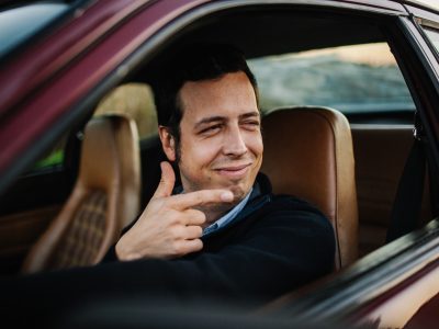 driving-man-looking-outside-driving-leather-seats-brown-car-portrait-funny_t20_Al6lVP